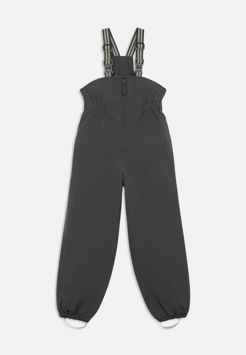 Dunkelgraue Latzhose mit verstellbaren gestreiften Trägern, elastischem Bund und elastischen Bündchen an den Knöcheln, die mit Metallschmuck verziert sind.