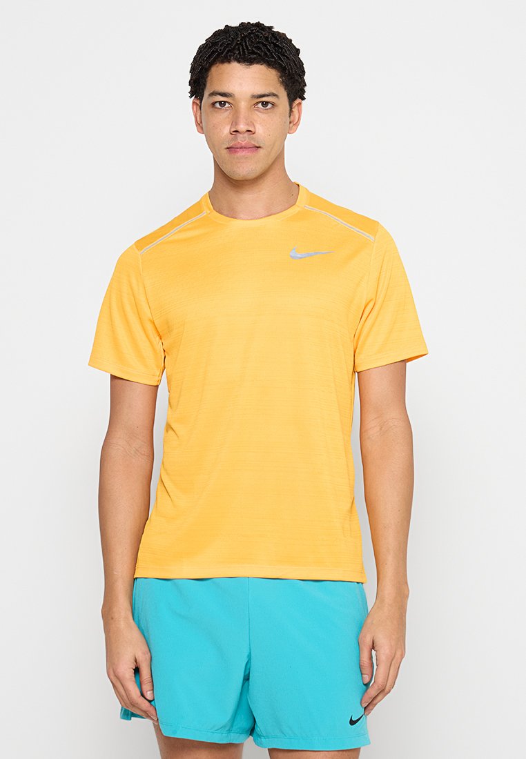 Nike T-Shirt mit kurzen Ärmeln in leuchtendem Gelb, mit silbernem Logo, glatter Textur und klassischem Design mit Rundhalsausschnitt.