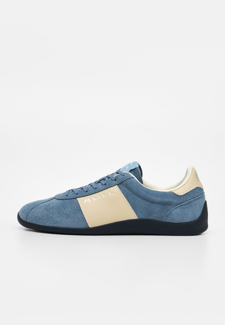 Blauer Wildleder-Sneaker mit beiger Seitenpartie, schwarzer Sohle und Schnürdesign, von der Seite auf weißem Hintergrund gezeigt.