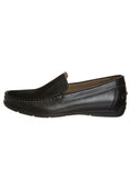 Schwarze Leder Slipper mit einer glatten Oberfläche, gesteppten Details entlang des Obermaterials und einer abgerundeten Zehenpartie, auf einer flachen Gummisohle.