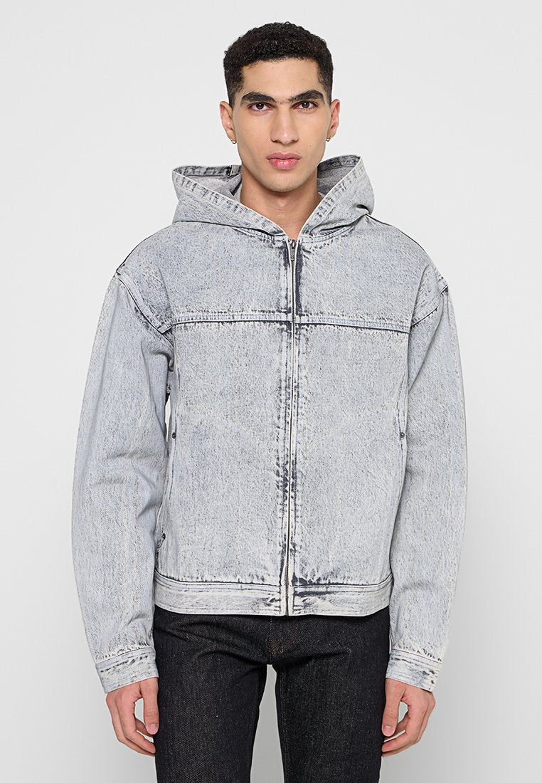 Hellgraue Denim-Jacke mit Kapuze, Frontreißverschluss, großen Taschen und genähten Details über der Brust und an den Ärmeln.