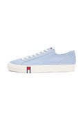 Hellblauer Canvas-Sneaker mit niedrigem Schaft, weißer Sohle und Schnürsenkeln, mit kleinem rechteckigem Logo an der Seite und auf der Zunge.