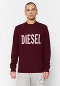 Burgunderfarbener Strickpullover mit Rundhalsausschnitt, der ein auffälliges "DIESEL"-Logo in Hellgrau auf der Vorderseite aufweist. Lange Ärmel und gerippter Saum.