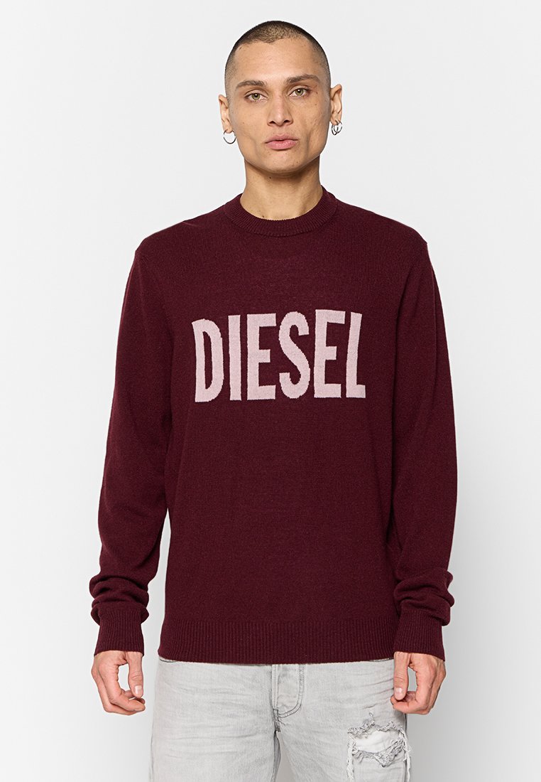 Burgunderfarbener Strickpullover mit Rundhalsausschnitt, der ein auffälliges "DIESEL"-Logo in Hellgrau auf der Vorderseite aufweist. Lange Ärmel und gerippter Saum.