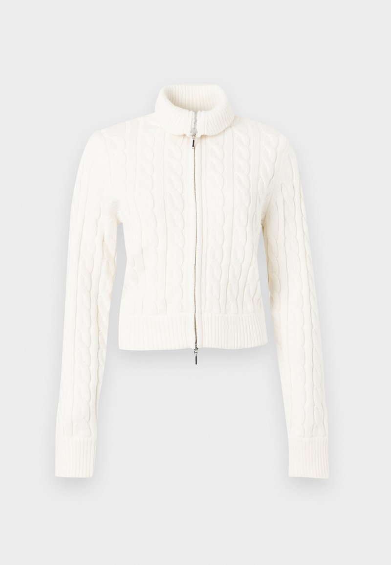 Gekürzter weißer Kabelstrickpullover mit hohem Kragen und Frontreißverschluss. Die Textur ist grob und weist gerippte Bündchen und einen gerippten Saum auf.