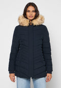 Marineblauer Puffer-Mantel mit Kapuze aus Kunstfell, vertikalen Nähten, zwei Fronttaschen und gerader Silhouette. Weicher Stoff und warmes Design.