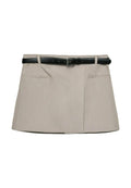 Beige Skort aus strukturiertem Stoff, mit einem schwarzen Ledergürtel und silberner Schnalle sowie zwei Fronttaschen. Kurzes, tailliertes Design.