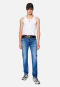 Weißes Tanktop, blaue Jeans, schwarzer Gürtel mit Logo, grau-weiße Sneakers, schwarze Mütze mit rotem Akzent. Lässiges Outfit mit modernem Design.