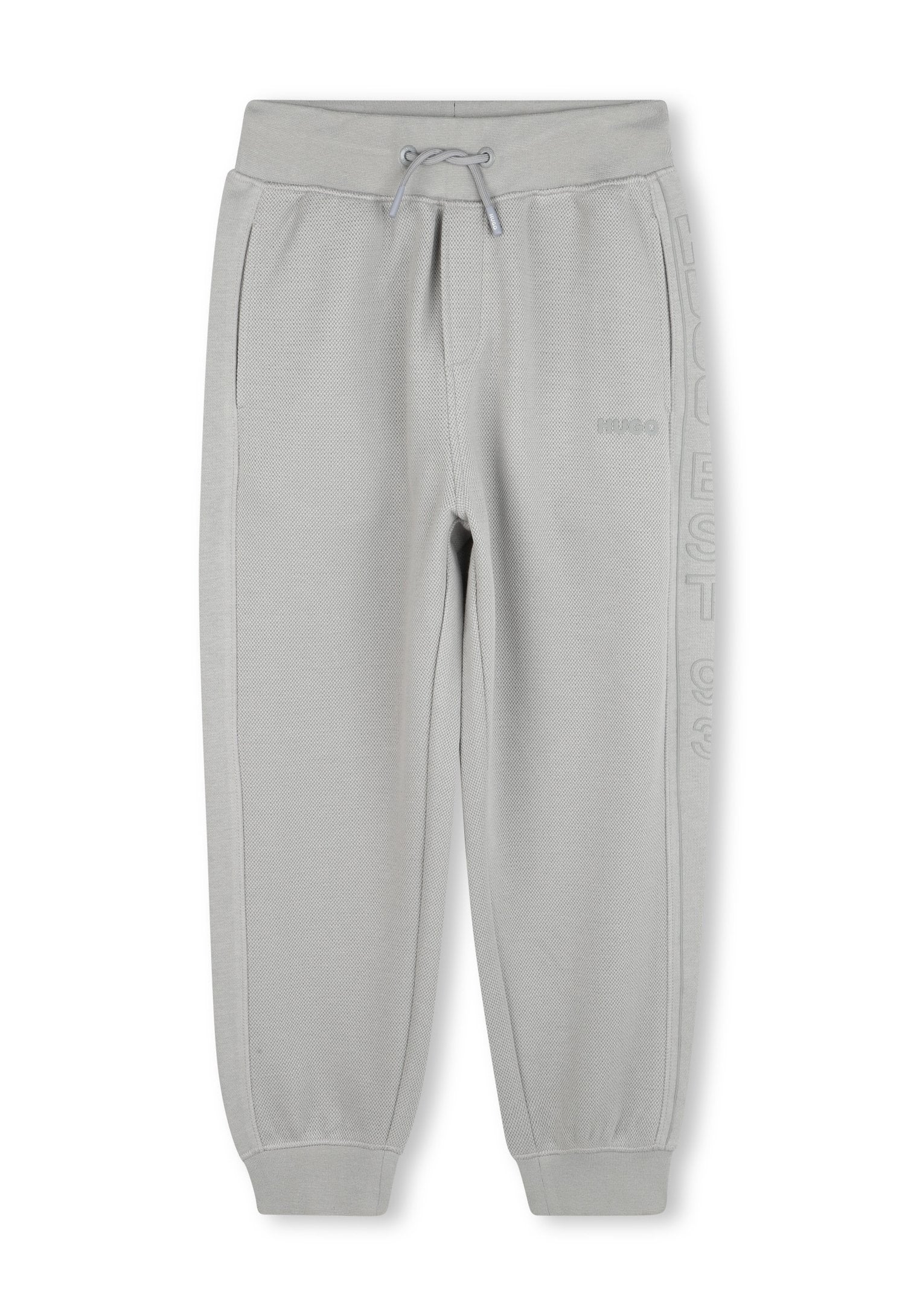 Hellgraue, texturierte Jogginghosen mit elastischem Bund, Kordelzug, seitlichen Taschen, gerippten Bündchen und dezentem "HUGO"-Logo am rechten Bein.