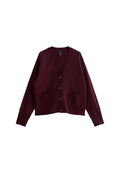 Burgunderfarbener Cardigan aus weichem Stoff, mit V-Ausschnitt, durchgehender Knopfleiste, zwei Fronttaschen und langen Ärmeln. Strukturierte Oberfläche.