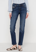 Dunkelblaue Denim-Jeans mit schlanker Passform, mittelhohem Bund, dezenten Used-Effekten und Fünf-Taschen-Design, kombiniert mit gemusterten Ballerinas.