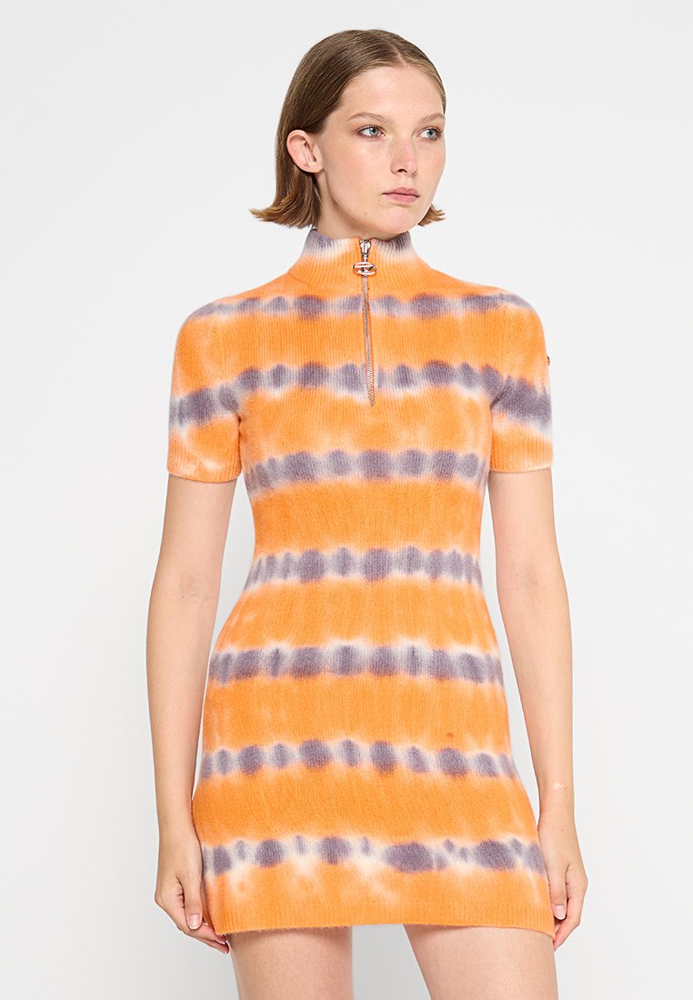 Kurzärmeliges, orangefarbenes Batikkleid mit lila Streifen, ausgestattet mit einem hohen Kragen und einem Reißverschluss vorne. Hergestellt aus einem gerippten Stoff.