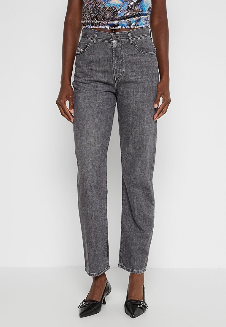 Graue gerade Jeans mit fünf Taschen und Gürtelschlaufen, aus Denim-Stoff gefertigt. Getragen mit schwarzen spitzen Absätzen und einem gemusterten Oberteil.