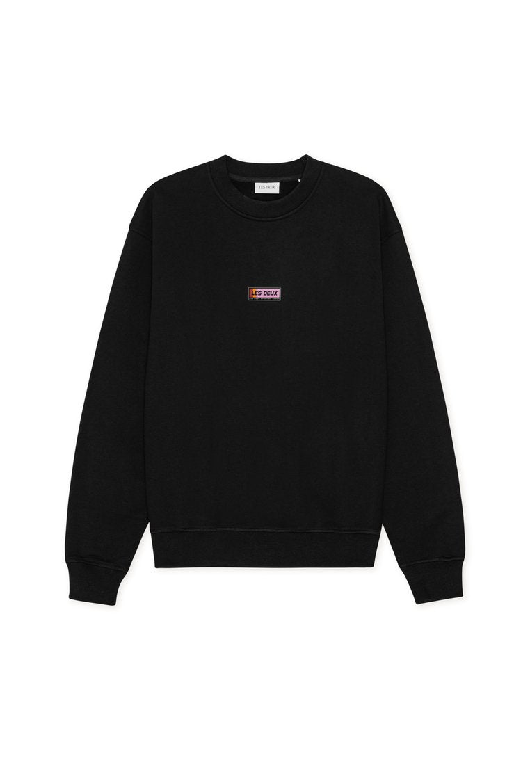 Schwarzer Sweatshirt mit Rundhalsausschnitt, langen Ärmeln und einem kleinen rechteckigen mehrfarbigen "LES DEUX"-Logo in der Mitte der Brust.