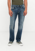 Blaue Denim-Jeans mit geradem Bein, leichter Ausbleichung und fünf Taschen. Kombiniert mit grauen Turnschuhen und einem grünen Oberteil.