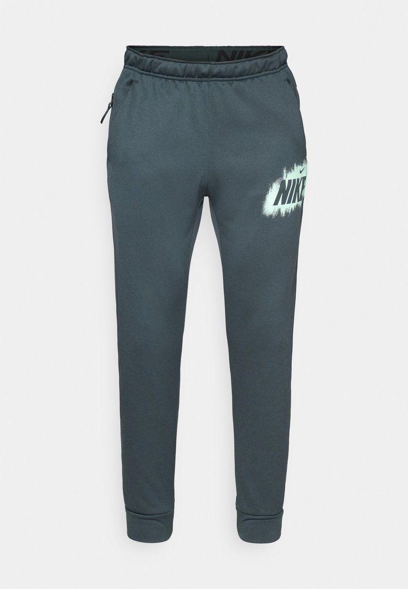 Dunkelgraue Jogginghosen aus weichem Stoff, mit einem elastischen Bund, seitlichen Taschen und einem großen weißen Nike-Logo mit Sprayeffekt.