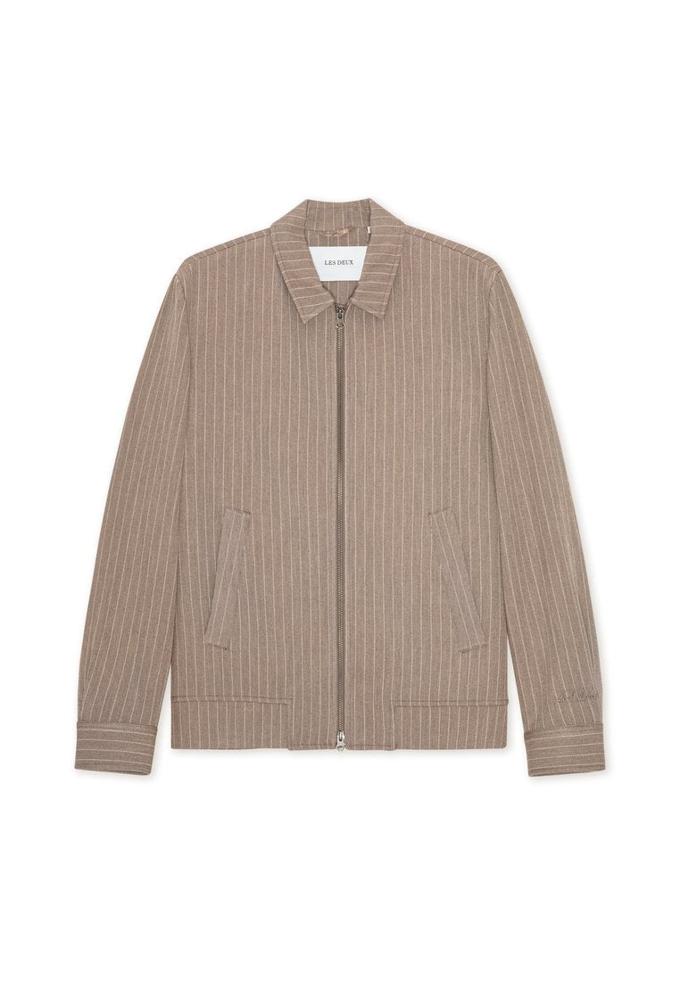 Beige Reißverschlussjacke mit vertikalen weißen Streifen, mit Kragen und Seitentaschen. Hergestellt aus strukturiertem Stoff mit glatter Oberfläche.
