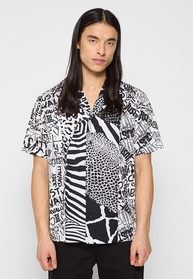 Kurzarmhemd mit einem Patchwork-Design, das schwarz-weiße Tiermuster, abstrakte Muster und handgezeichnete Textelemente aufweist.