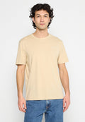 Beige Baumwoll-T-Shirt mit rundem Ausschnitt und kurzen Ärmeln. Kleiner weißer Logo-Schriftzug auf der linken Brustseite. Normale Passform.