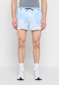 Mann trägt hellblaue Nike-Laufshorts mit Reißverschlusstaschen, weiße Socken und weiße Sportschuhe, steht vor einem schlichten Hintergrund.