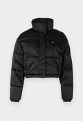 Gekürzte schwarze Daunenjacke mit hohem Kragen, gestepptem Design, elastischen Bündchen und einem kleinen Logo auf der linken Seite. Glattes, glänzendes Material.