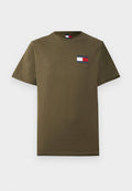 Olivgrünes Baumwoll-T-Shirt mit kurzen Ärmeln und einem kleinen Tommy Jeans Logo-Patch in Rot, Weiß und Marineblau auf der linken Brust.
