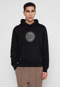 Schwarzer Kapuzenpullover mit Kordelzug, ausgestattet mit einem kreisförmigen Grafikdesign in Weiß auf der Brust. Das Material wirkt weich und verfügt über eine Vordertasche.