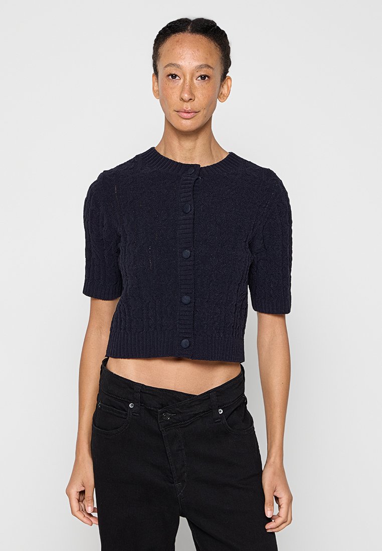 Marineblauer, kurz geschnittener Cardigan mit kurzen Ärmeln, strukturiertem Zopfmuster und sechs passenden Knöpfen vorne. Gerippte Bündchen und Saum.