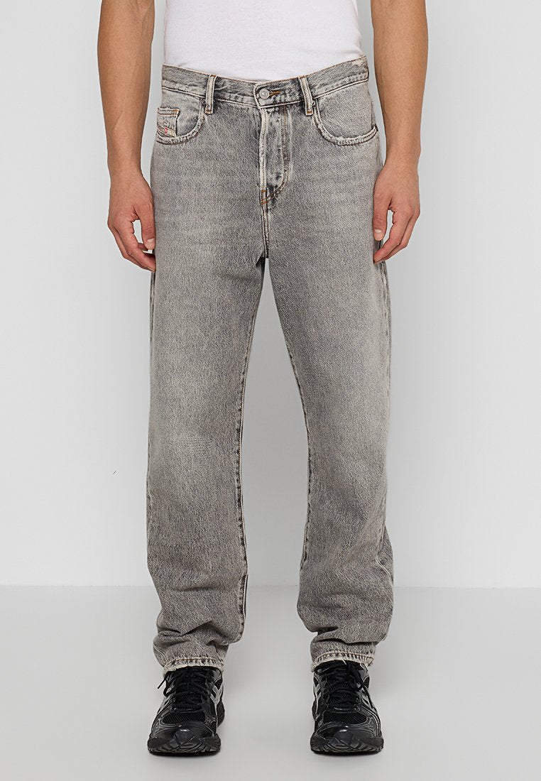 Graue Denim-Jeans mit lockerer Passform, ausgestattet mit Fronttaschen und einem Knopfverschluss. Die Textur ist leicht ausgebleicht und verleiht einen abgetragenen Effekt.