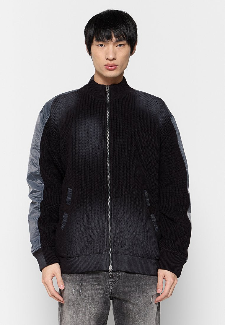 Schwarze Strick-Bomberjacke mit grauen Einsätzen, Reißverschluss, geripptem Kragen und Taschen. Strukturierter Stoff sorgt für einen Kontrast im Design und in der Farbe.