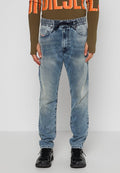 Hellblaue Jeans mit schmalem Schnitt, elastischem Bund und Kordelzug; getragen mit einem langärmeligen, olivgrünen Oberteil.
