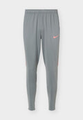 Graue Sporthose mit elastischem Bund und schmaler Passform, mit einem kleinen pinken Nike-Swoosh-Logo am rechten Oberschenkel.