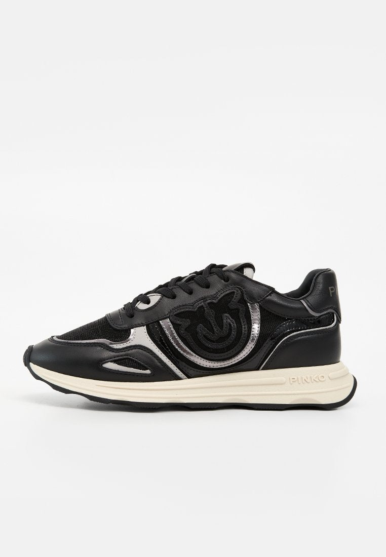 Schwarzer und silberner Sneaker mit Schnürdesign, strukturiertem Stoff und Leder, weißer Sohle und gesticktem Logo an der Seite.