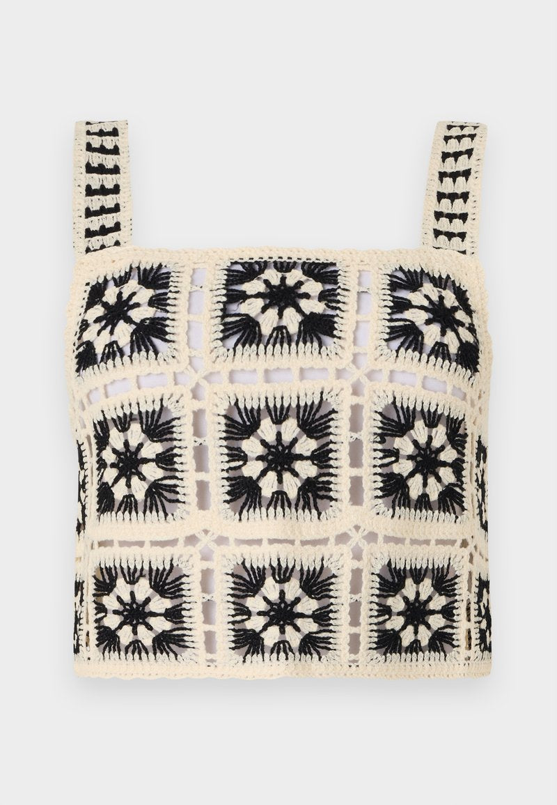 Häkel-Crop-Top mit einer cremfarbenen Basis, schwarzer floraler Stickerei, quadratischen Motiven und verstellbaren Trägern. Das offene Gewebedesign verleiht Textur.