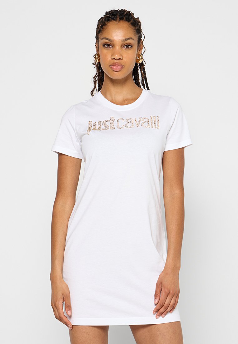 Weißes T-Shirt-Kleid mit rundem Ausschnitt und kurzen Ärmeln. Vorderseite verziert mit funkelndem "justcavalli"-Schriftzug in Gold. Weicher Baumwollstoff.