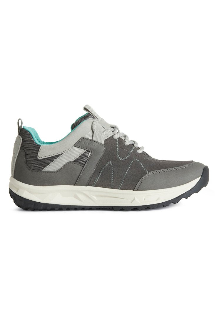 Grauer Sportschuh mit einem Obermaterial aus strukturiertem Stoff, weißer Zwischensohle, schwarzem Gummiboden und türkisfarbener Akzentierung. Verfügt über ein geschwungenes Design und Schnürsenkel.