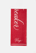 Rotes Handtuch mit weißem, geschwungenem Text, der "Breaker" liest, und einem kleineren "Hugo" am unteren Rand. Es besteht aus weichem Stoff mit glatter Textur.