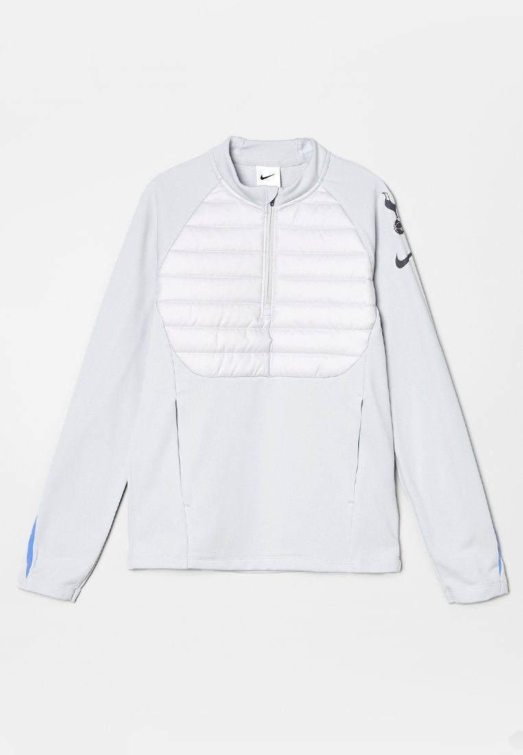 Helles grau Pullover mit einem Viertel-Reißverschluss, gepolsterter weißer Brustplatte und blauen Akzenten an den Ärmeln. Mit einem Nike-Logo auf dem linken Arm.