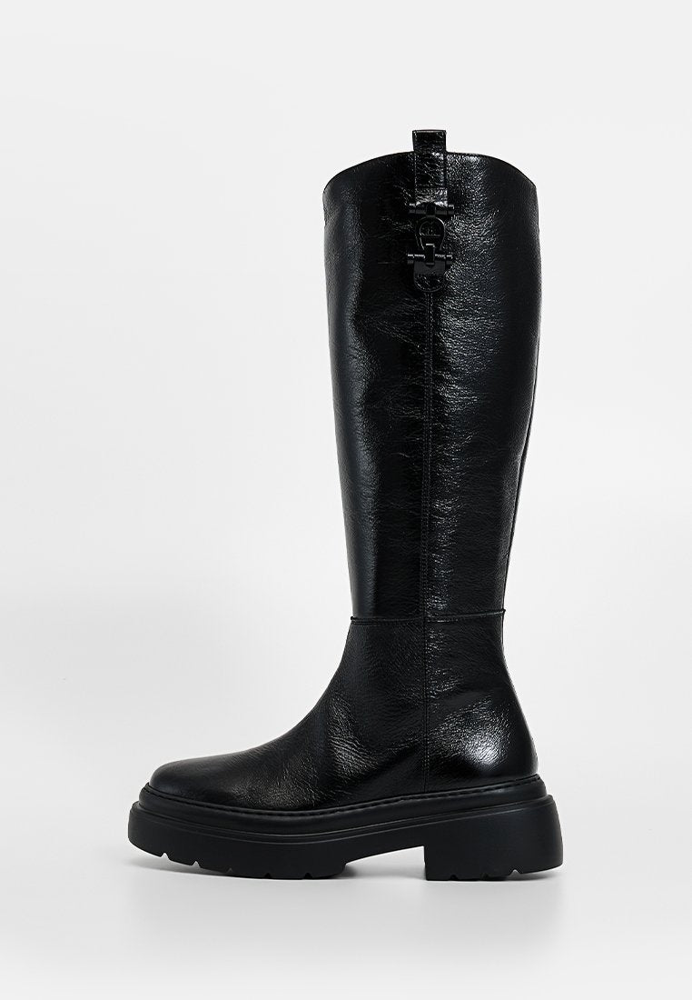 Schwarzer kniehoher Stiefel aus glänzendem Material, mit klobiger Sohle, glatter Textur und einem dekorativen Riemen mit Metallbeschlägen oben.