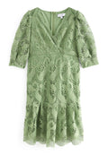 Grünes Spitzenkleid mit V-Ausschnitt, halben Ärmeln und weitem Saum. Aufwendiges Paisley-Muster; glatte Textur. Reißverschluss hinten.