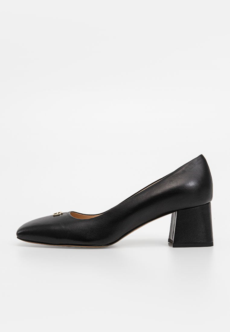 Schwarzer Leder-Pump mit runder Zehenpartie und Blockabsatz. Minimalistisches Design mit einem kleinen dekorativen Akzent im Obermaterial. Glatte Textur.