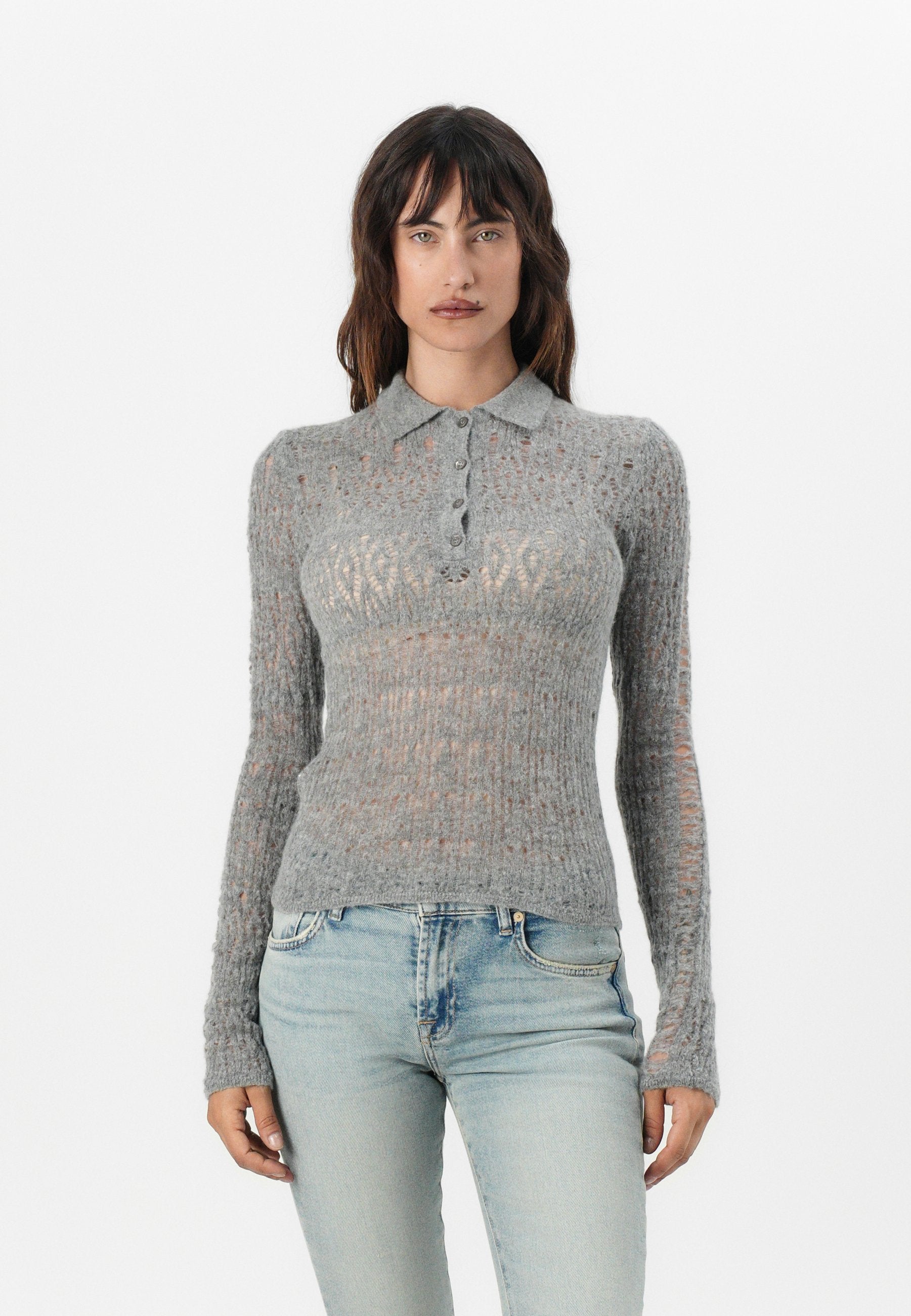 Hellgraues Poloshirt mit langen Ärmeln, das eine gerippte Textur und ein offenes Strickmuster aufweist. Mit einer Knopfleiste und einem figurbetonten Design.