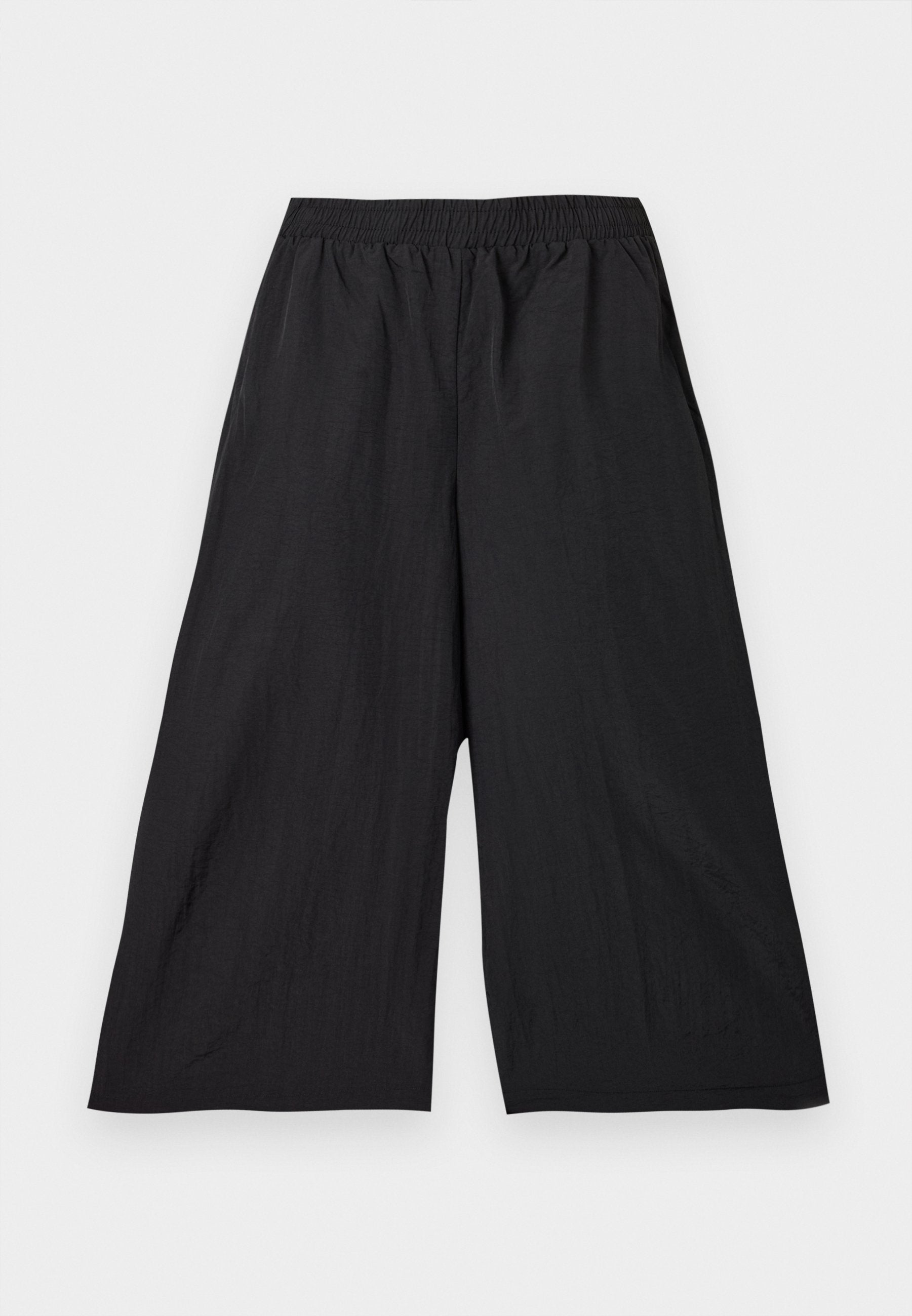 Schwarze, weit geschnittene, verkürzte Hose mit elastischem Bund aus leichtem Stoff, flach auf hellem Hintergrund präsentiert.