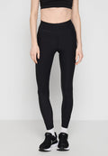 Schwarze Leggings mit hohem Bund, aus dehnbarem Material. Kombiniert mit einem schwarzen Crop-Top und schwarzen Sneakers mit weißen Akzenten.
