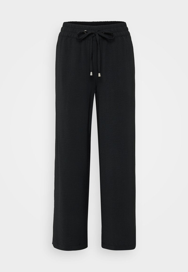 Schwarze, weit geschnittene Hose aus einem weichen Stoff. Verfügt über einen elastischen Bund mit einem Kordelzug und metallischen Enden. Glatte Textur, keine Muster.