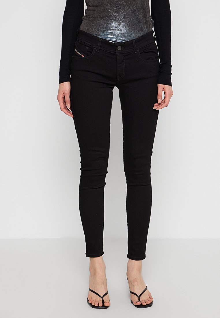 Schwarze Denim Skinny Jeans mit hoher Taille, Knopfverschluss, fünf Taschen und leichtem Stretch für Komfort. Mit dezenten Nähten akzentuiert.