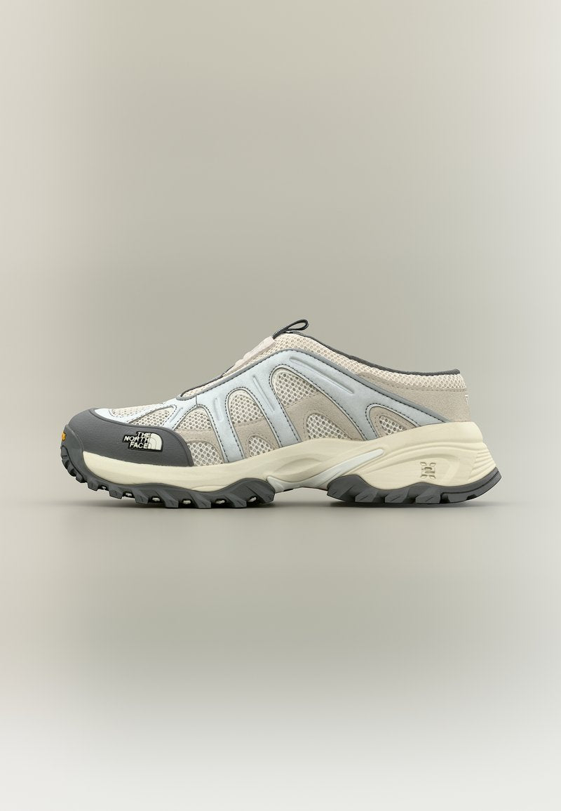 Beiger, grauer und weißer Slip-on-Wanderschuh mit Mesh- und Gummisohle, auf der Zehenkappe mit "The North Face" Marke, Seitenansicht.