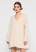 Beiges Kleid mit V-Ausschnitt, langen Ärmeln und einem auslaufenden Saum. Glatte Textur, minimales Design und keine sichtbaren Muster oder Verzierungen.