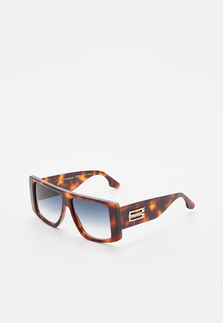 Schildpatt rechteckige Sonnenbrille mit blauen Verlaufslinsen und goldenem Emblem an den breiten Bügeln, auf weißem Hintergrund präsentiert.