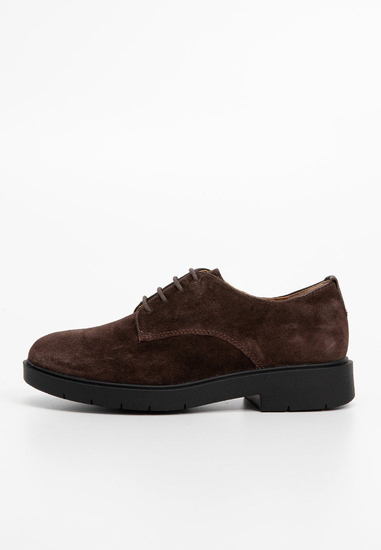 Braune Wildleder-Oxford-Schuhe mit abgerundetem Kopf, schwarzer Gummisohle und traditionellem Schnürdesign. Glatte Textur und minimale Nähdetails.